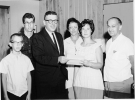 Brenda Miller receives 1st Scholarship. Given by GM Director Leonard Woodcock. Surrounded by family: Father Harry Miller, shown at right, a tool maker and long time member of Fisher 21 of Local 157 in Detroit. Also pictured are Brenda’s Brothers, Howard and Bernard, and her mother, Mrs. Frances Miller