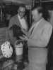 Walter Reuther, right, Chairman of the C.I.O. is shown in a Paris shop Aug. 29, trying to decide which of these bags his wife would like best.  With him is Daniel Benedict, left, Assistant Director of International Affairs for the C.I.O. the labor leader is enroute to Israel and while in Paris conferred with French labor representatives."August 29, 1955