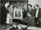 Walter Reuther Looking at March of Dimes poster, (hand in brace, seated at desk)-Left to Right:   Emil Mazey, unidentified lady, Walter Reuther, Jack Livingston, Richard Gosser"ca. 1948